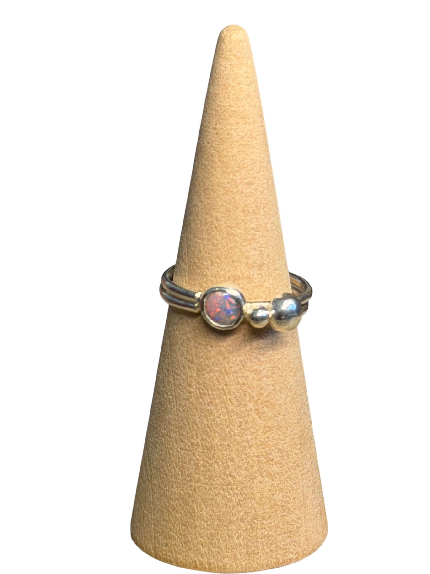 Ring on a cone-shaped jewelry display stand against a white background